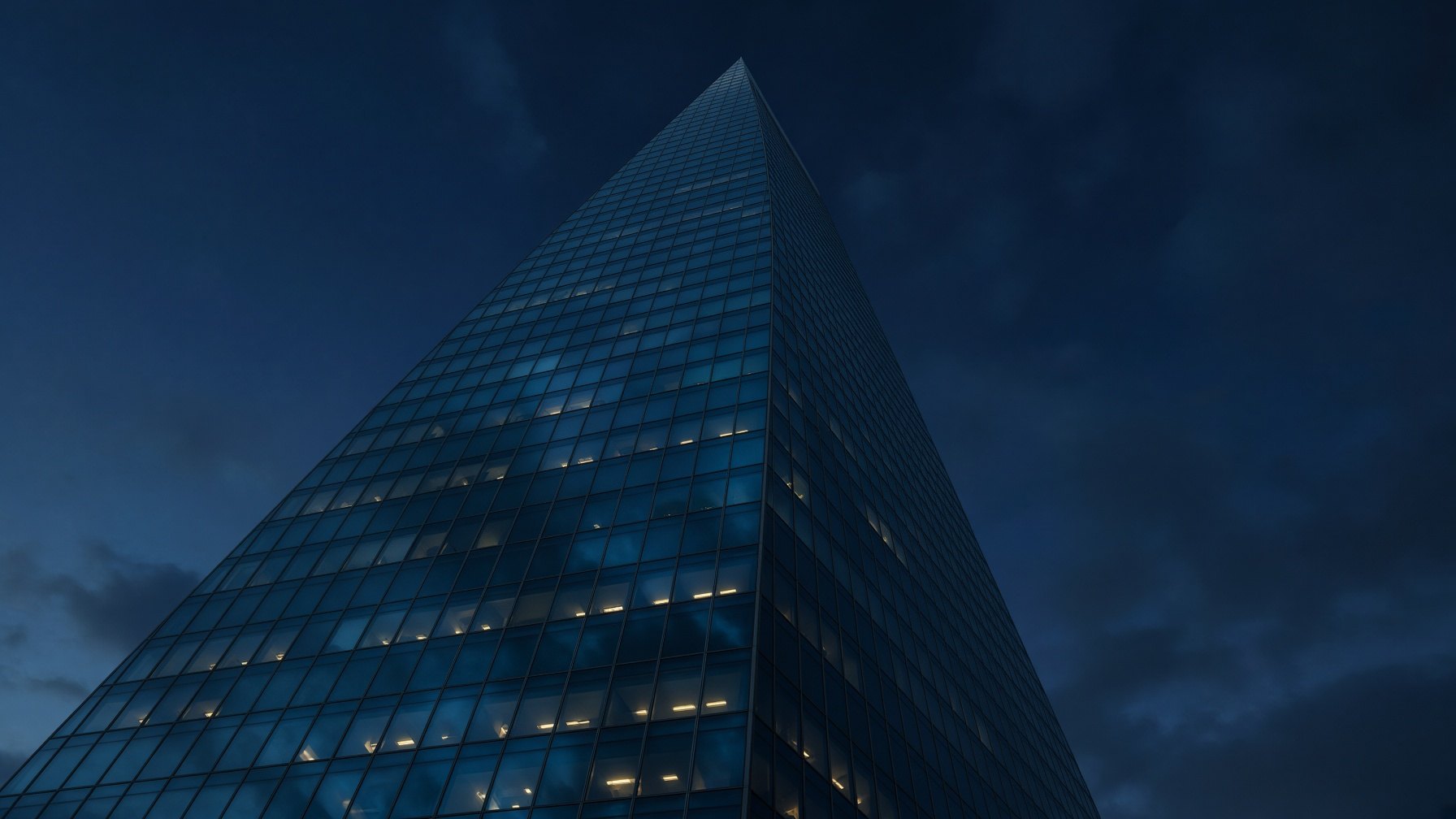 Looking upward at a glass tower at dusk